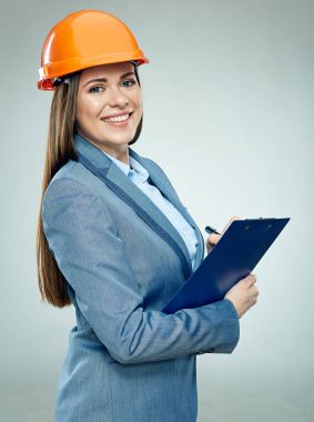 gülümseyen kadın portakal koruyucu kask gri arka plan üzerinde panosuna yazma içinde