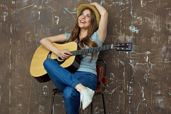 Mulher com guitarra acústica sentada na cadeira — Fotografia de Stock