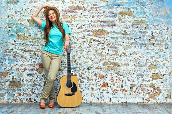 tuğla duvara yaslanmış gitar kadınla 