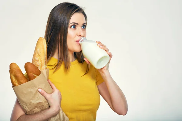 Kobieta pije mleko i trzyma chleb — Zdjęcie stockowe
