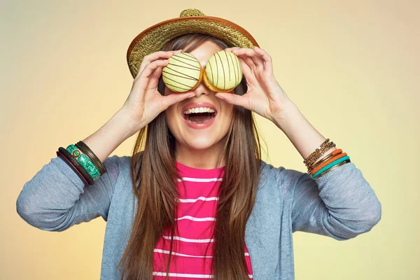 Mujer divertida sostiene dos pasteles delante de los ojos . — Foto de Stock