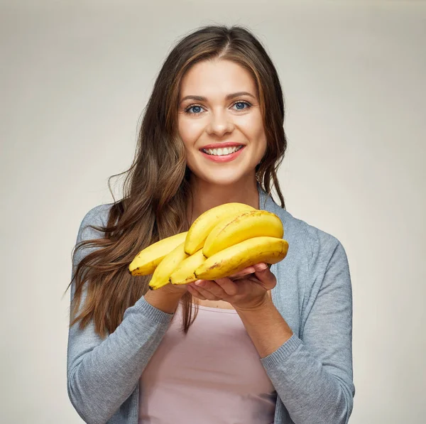 Lächelnde Frau mit langen Haaren und Banane in der Hand. — Stockfoto