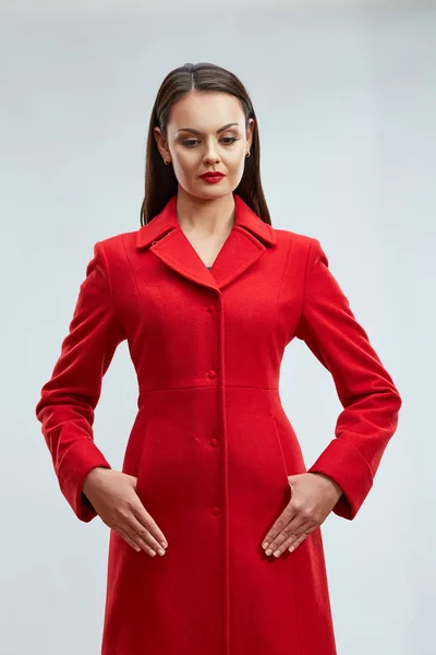 Divat-model, pózol, piros kabátot ellen elszigetelt studio backgro — Stock Fotó
