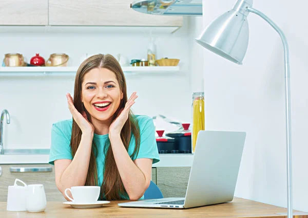 Kvinna med laptop sitter i köket — Stockfoto