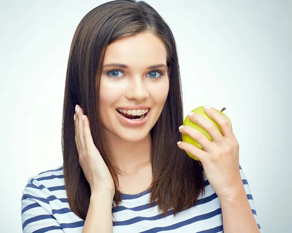 Kobieta z szelkami na zębach trzyma jabłko — Zdjęcie stockowe