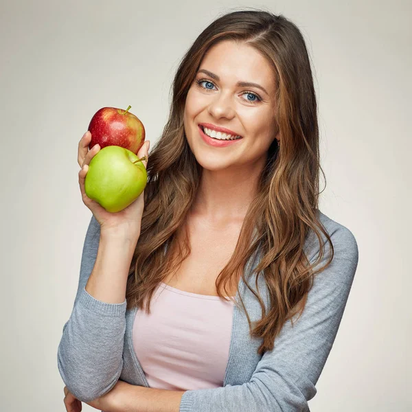 Lächelnde junge Frau mit zwei Äpfeln, rot und grün. — Stockfoto