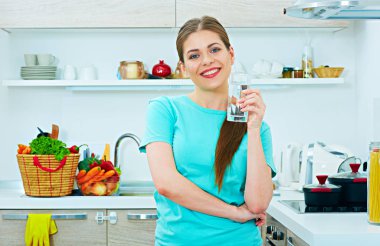 Su bardağı tutan gülümseyen genç kadın. 