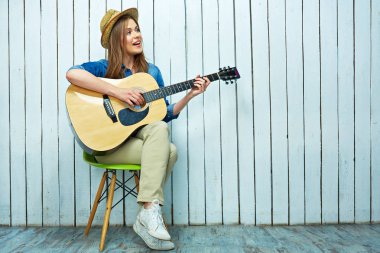 Genç kadın oyun gitar ve şarkı söyler. 