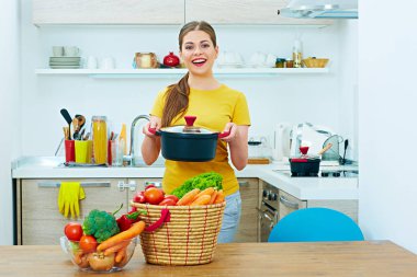 Gülümseyen kadın mutfakta pan holding. 