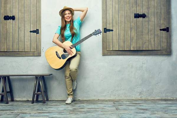 Portret uśmiechający się kobiety z gitarą akustyczną. — Zdjęcie stockowe