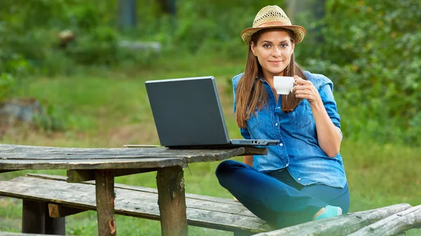 Portrét ženy pití kávy a pomocí přenosného počítače — Stock fotografie