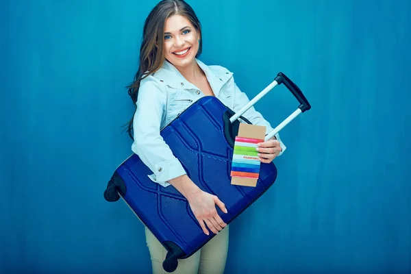 Uśmiechnięta młoda kobieta trzyma walizkę, paszport, bilet — Zdjęcie stockowe