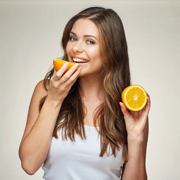 Mujer sonriente comiendo naranja. media fruta . — Foto de Stock