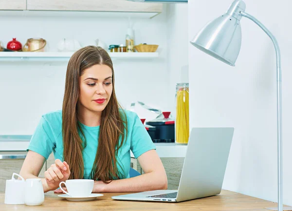 woman work at home kitchen with laptop