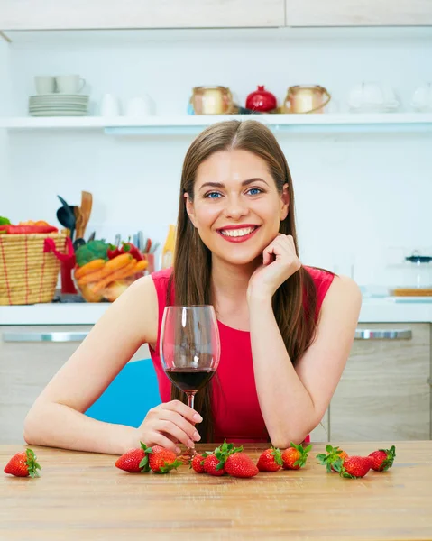 Retrato de mujer sonriente en cocina con copa de vino . —  Fotos de Stock