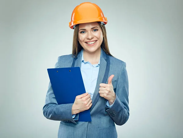 Sonriente mujer de negocios con casco de seguridad sujetando portapapeles —  Fotos de Stock