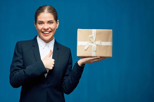Business kvinna klädd i svart kostym holding presentbox ger tummen — Stockfoto