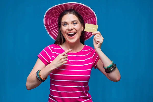 Усміхнена жінка в пляжному капелюсі вказує пальцем на золотий кредит c — стокове фото
