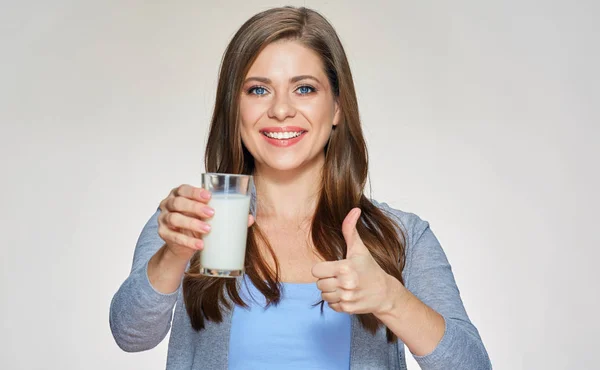 Mujer sonriente sosteniendo vaso de leche muestra el pulgar hacia arriba . —  Fotos de Stock