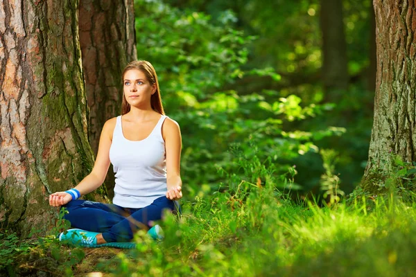 Mujer joven practica yoga en la madera . — Foto de Stock