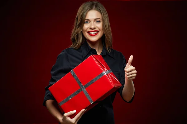 Usmívající se žena hospodářství červené dárkové krabice černé šaty nosí — Stock fotografie