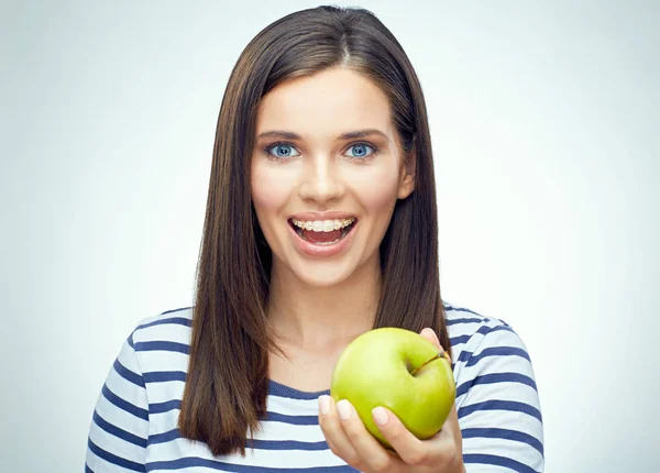 Chica feliz con frenos dentales sosteniendo manzana verde . —  Fotos de Stock