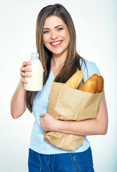 Sonriente mujer feliz sosteniendo bolsa de papel con pan y muestra la leche —  Fotos de Stock