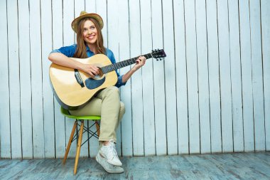 Genç kadın oyun gitar ve şarkı söyler. 