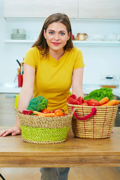 Vrouw met groenten op rieten manden — Stockfoto