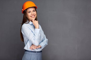 gri duvara karşı ayakta gülümseyen kadın mimar.