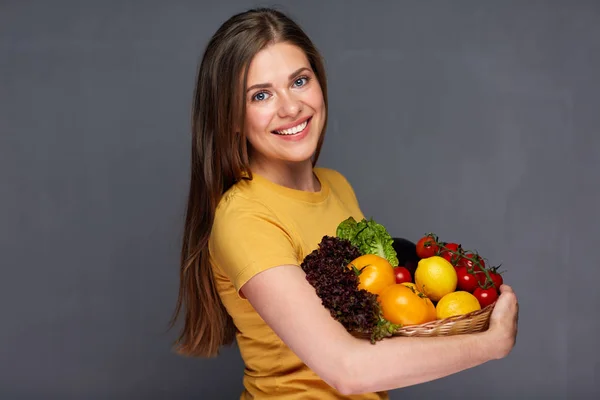 Femme souriante tenant des ingrédients alimentaires végétaliens . — Photo
