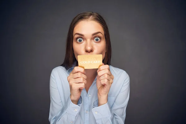 Frau hält Kreditkarte vor Mund. — Stockfoto