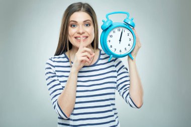 Genç bir kadın saati tutuyor. 