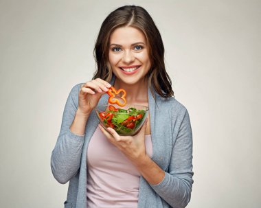 Sebze salatası yiyen genç bir kadın.