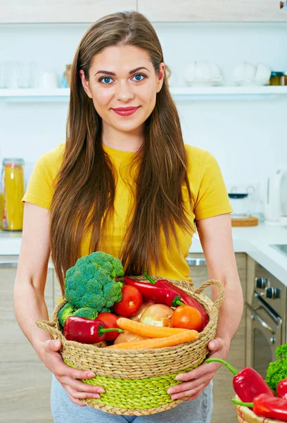 Woman holding wicker basket with vegetables — Stock Photo, Image