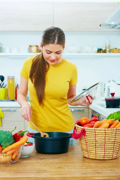 Woman cooking food in kitchen — Stock Photo, Image