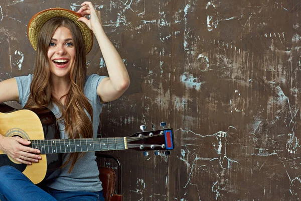 Усміхнена жінка тримає гітару — стокове фото