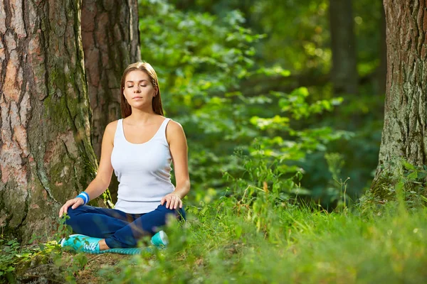 Giovane donna pratica yoga nel legno . — Foto Stock