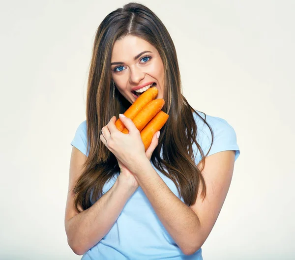 Une femme souriante mord la carotte. Portrait isolé en studio . — Photo
