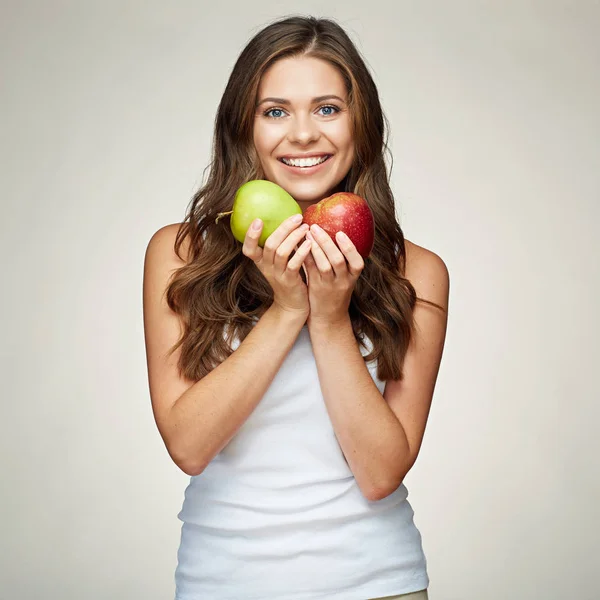 Leende kvinna med friska tänder håller röda och gröna äpplen. — Stockfoto