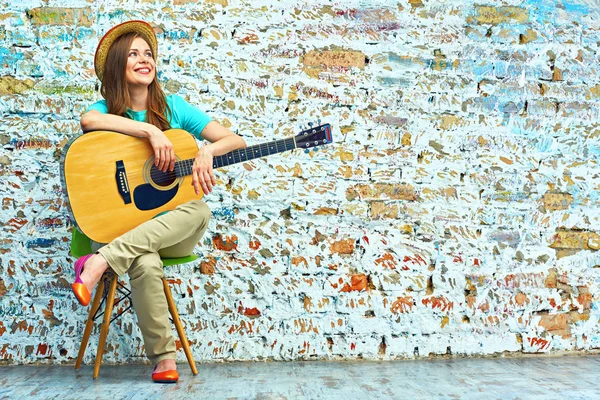 Sorrindo jovem mulher sentada com guitarra — Fotografia de Stock