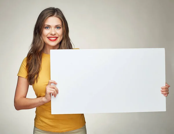 Leende kvinna håller vit reklam skylt styrelse. — Stockfoto