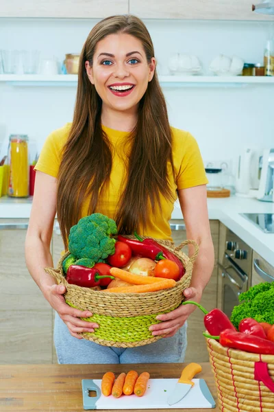 Mujer sosteniendo cesta de mimbre con verduras — Foto de Stock
