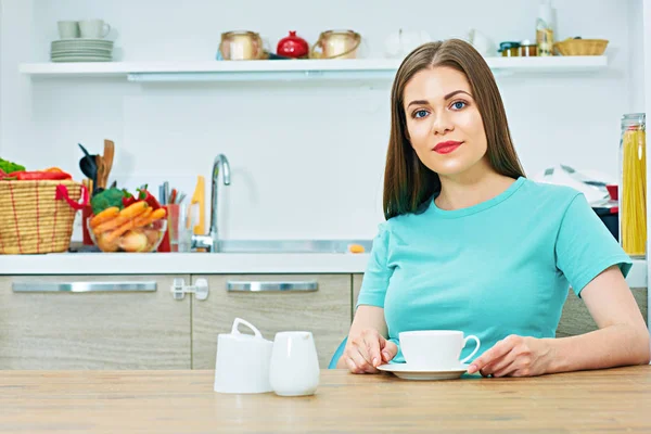 Mulher sentada na cozinha com xícara de café — Fotografia de Stock