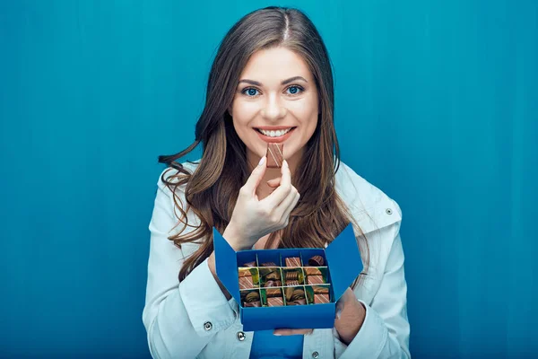 Glückliche junge Frau isst Schokoladenbonbons. — Stockfoto