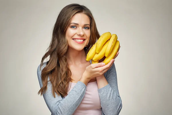 Mujer sonriente sosteniendo plátanos amarillos —  Fotos de Stock