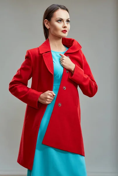 Модель в червоному пальто і синій сукні — стокове фото