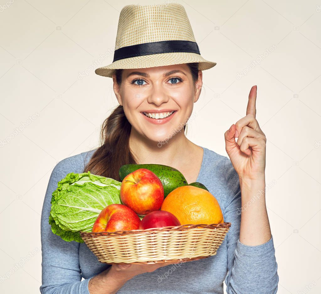 woman holding wicker basket with fruits