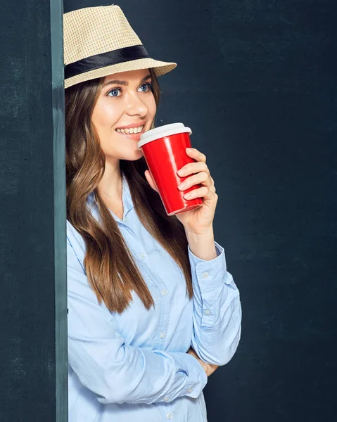 Portret van een jonge vrouw met koffiekopje tegen zwarte muur. — Stockfoto