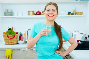 Su bardağı tutan gülümseyen genç kadın. 